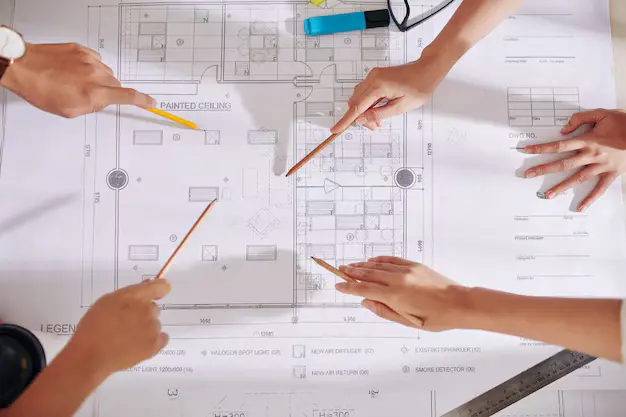 hands architects designers pointing blueprint table when discussing future interior design project 274689 20802