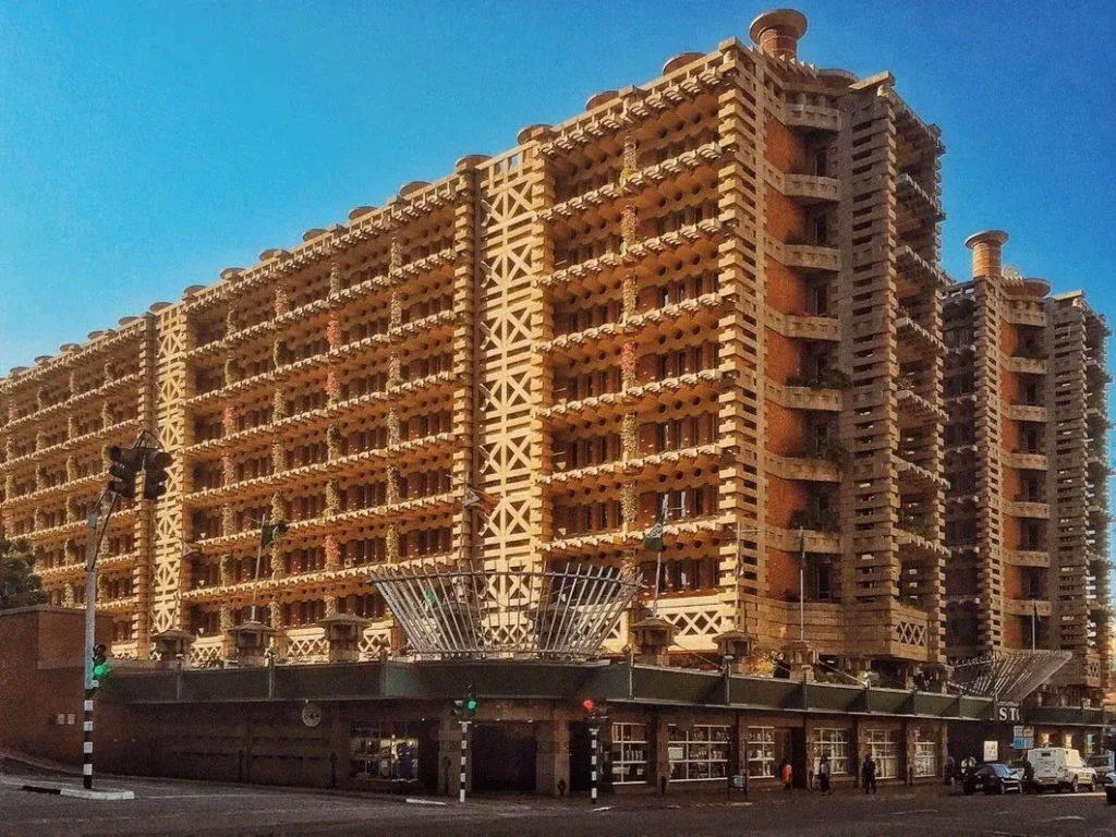 10 نمونه برجسته از معماری بیومیمتیک: الهام از طبیعت برای آیندهای پایدار 3 ساختمان چند طبقه با معماری خاص و نمای سنگی طرحدار همراه با بالکنهای کوچک.